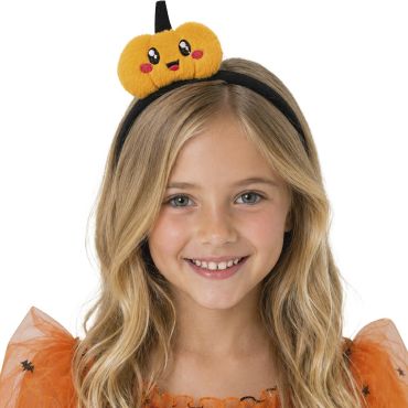 Petite fille souriante portant un serre-tête d'Halloween avec une citrouille orange en peluche kawaii | jourdefete.com